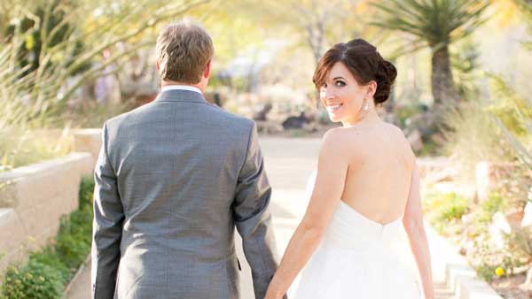 Bride looks back at Springs Preserve wedding. Photo by J. Anne Photography.